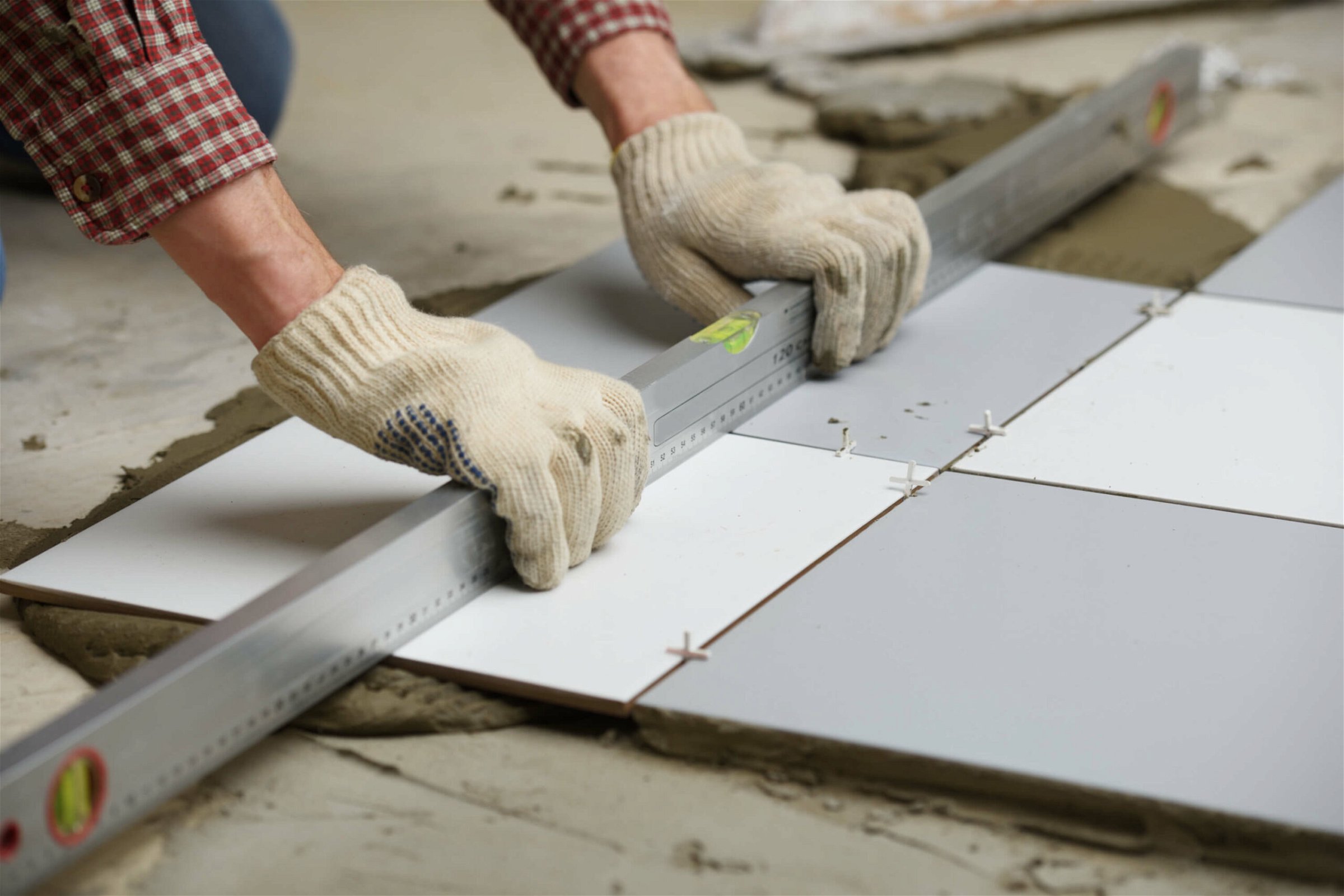 A man is laying tile on a floor for residential flooring solutions.